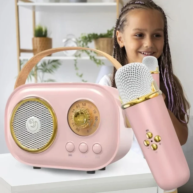 Портативна Bluetooth колонка для караоке бежевого (або рожевого) кольору з бездротовим мікрофоном, що стоїть на столі.